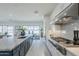 Bright open kitchen with white cabinets, stainless steel appliances, and an island with marble countertop at 24000 S 218Th Pl, Queen Creek, AZ 85142