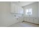 Well-lit laundry room boasts ample storage with white cabinets and a convenient countertop at 24000 S 218Th Pl, Queen Creek, AZ 85142