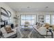 Spacious living area with white sofas, a patterned rug, and large windows offering backyard views at 24000 S 218Th Pl, Queen Creek, AZ 85142