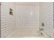 Bright bathtub and shower combo with white subway tile walls and decorative recessed shelf at 26521 N Babbling Brook Dr, Phoenix, AZ 85083
