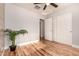 Bright bedroom featuring hardwood floors, closet, a modern ceiling fan, and a leafy potted plant at 26521 N Babbling Brook Dr, Phoenix, AZ 85083