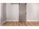 Bedroom features hardwood floors and a modern sliding barn door at 26521 N Babbling Brook Dr, Phoenix, AZ 85083