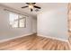 Bedroom features wood floors, ceiling fan, and bright window at 26521 N Babbling Brook Dr, Phoenix, AZ 85083