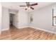 Bright bedroom with wood floors features a ceiling fan and entry to hallway at 26521 N Babbling Brook Dr, Phoenix, AZ 85083