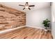 Bedroom featuring a wooden accent wall, hardwood floors, and a ceiling fan at 26521 N Babbling Brook Dr, Phoenix, AZ 85083