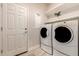 Laundry room featuring white washer and dryer, white cabinets and shelves, and bright lighting at 26521 N Babbling Brook Dr, Phoenix, AZ 85083