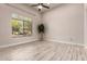 Bright living room featuring wood-look tile flooring, neutral walls, and a large window at 26521 N Babbling Brook Dr, Phoenix, AZ 85083