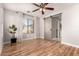 Bright bedroom with hardwood floors, a ceiling fan, and a sliding barn door to the ensuite at 26521 N Babbling Brook Dr, Phoenix, AZ 85083