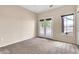 Cozy bedroom with neutral carpet, natural light from a large window and French doors, creating a serene retreat at 27347 N Gary Rd, San Tan Valley, AZ 85144