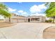 Charming stucco home featuring a spacious driveway, an attached two-car garage and decorative wood beam accents at 27347 N Gary Rd, San Tan Valley, AZ 85144