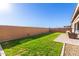 Large backyard featuring a manicured lawn, paver patio, and a tall privacy wall at 32582 N Durango Ln, San Tan Valley, AZ 85143