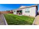 Serene backyard with green lawn, covered patio, and meticulous gravel and paver border details at 32582 N Durango Ln, San Tan Valley, AZ 85143