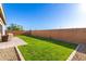 Expansive backyard with green lawn, paver patio area, and secure brick wall for privacy at 32582 N Durango Ln, San Tan Valley, AZ 85143