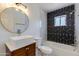 Modern bathroom with white vessel sink, stylish black and white tile, and a shower-tub combination at 343 S Cholla St, Gilbert, AZ 85233