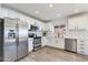 Modern kitchen featuring stainless steel appliances, white cabinets, subway tile backsplash, and wood look floors, all well-lit at 343 S Cholla St, Gilbert, AZ 85233