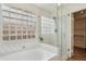This bathroom features a glass-enclosed shower, soaking tub, and tiled walls at 4043 N Ranier --, Mesa, AZ 85215