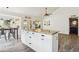 Bright kitchen features a white island with granite countertops, stylish light fixtures, and wood-look flooring at 4043 N Ranier --, Mesa, AZ 85215