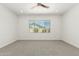 Bright and airy bedroom with neutral carpet, ceiling fan, and large window with neighborhood views at 4051 S Galaxy Ln, Mesa, AZ 85212