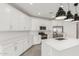 Modern kitchen features white cabinets, stainless steel appliances, and a large island with quartz countertop at 4051 S Galaxy Ln, Mesa, AZ 85212