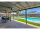 Covered patio with ceiling fan overlooking the lush backyard and swimming pool with spa at 4137 E Sells Dr, Phoenix, AZ 85018