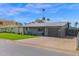 This single-story home has a well-kept lawn, attached garage, and is surrounded by palm trees at 4137 E Sells Dr, Phoenix, AZ 85018