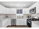 Stylish kitchen with white cabinets, stainless steel appliances and a window above the sink at 4137 E Sells Dr, Phoenix, AZ 85018