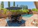 Serene backyard with outdoor dining area under an umbrella, pool, and lush greenery at 4141 E Morrison Ranch Pkwy, Gilbert, AZ 85296