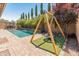 Charming backyard with a pool, swing set, lush greenery, and well-maintained landscaping at 4141 E Morrison Ranch Pkwy, Gilbert, AZ 85296
