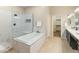 Spa-like bathroom featuring marble accents, a tub, glass shower, and modern fixtures at 4141 E Morrison Ranch Pkwy, Gilbert, AZ 85296