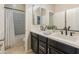 Elegant bathroom with double sinks, dark cabinetry, and a tub with decorative tile surround at 4141 E Morrison Ranch Pkwy, Gilbert, AZ 85296