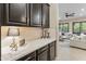 Elegant counter with dark cabinets and decor that leads to an open living area with lots of natural light at 4141 E Morrison Ranch Pkwy, Gilbert, AZ 85296
