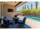 Inviting covered patio with outdoor furniture overlooking a sparkling pool with lush landscaping at 4141 E Morrison Ranch Pkwy, Gilbert, AZ 85296