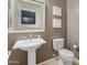 Stylish powder room featuring a pedestal sink, decorative mirror, and modern fixtures at 4141 E Morrison Ranch Pkwy, Gilbert, AZ 85296