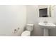 Clean half-bathroom with a toilet, sink, and mirror at 41804 W Carlisle Ln, Maricopa, AZ 85138