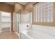 Bright bathroom featuring a separate shower, bathtub, and tiled floor at 41804 W Carlisle Ln, Maricopa, AZ 85138
