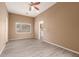 Bright bedroom with wood-look flooring, a window, and access to the laundry room at 41804 W Carlisle Ln, Maricopa, AZ 85138