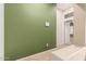 Hallway with an olive green accent wall, tiled floors, and a doorway into another room at 41804 W Carlisle Ln, Maricopa, AZ 85138