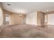 Large open-concept living area with carpet flooring and a chandelier at 41804 W Carlisle Ln, Maricopa, AZ 85138