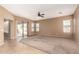 Bright living room with tile entry, ceiling fan, neutral paint, and access to the backyard at 41804 W Carlisle Ln, Maricopa, AZ 85138