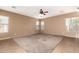 Light-filled living room with multiple windows, neutral paint, and plush carpet flooring at 41804 W Carlisle Ln, Maricopa, AZ 85138