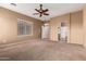 Expansive main bedroom with neutral paint, ceiling fan, carpet, and ensuite bathroom at 41804 W Carlisle Ln, Maricopa, AZ 85138