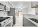 Well-lit kitchen with gray cabinets, stainless steel appliances, and a dining area at 420 W Yukon Dr # 4, Phoenix, AZ 85027
