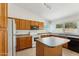 Functional kitchen with wood cabinetry, essential appliances, and a central island for meal preparation and casual dining at 4202 E Brookwood Ct, Phoenix, AZ 85048
