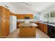 Kitchen with wood cabinetry, essential appliances, and a central island at 4202 E Brookwood Ct, Phoenix, AZ 85048