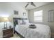 Cozy bedroom with a ceiling fan, comfortable bed with patterned bedding, and a dark wood nightstand at 4240 E Bluefield Ave, Phoenix, AZ 85032