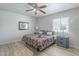 Inviting bedroom with ceiling fan, a nightstand, and comfortable bed with red and gold patterned bedding at 4240 E Bluefield Ave, Phoenix, AZ 85032
