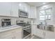 Bright kitchen features stainless steel appliances, white cabinetry, and a subway tile backsplash at 4240 E Bluefield Ave, Phoenix, AZ 85032