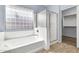 Bright bathroom featuring a glass-enclosed shower, soaking tub, and privacy window at 4396 E Austin Ln, San Tan Valley, AZ 85140