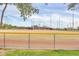 Community baseball field with chain link fence, dugouts, and mature shade trees at 4408 W Heyerdahl Dr, New River, AZ 85087