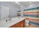 Well-lit bathroom with double sink vanity and colorful shower curtain at 4408 W Heyerdahl Dr, New River, AZ 85087